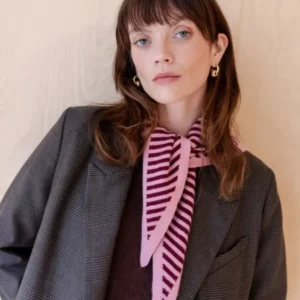 Pink and burgundy striped merino triangle scarf by TBCo styled with grey plaid blazer and burgundy jumper against beige backdrop