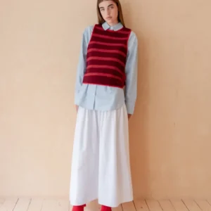 Model wearing TBCo Merino Wool Tie Vest in Burgundy Stripe over blue shirt with white skirt and black shoes